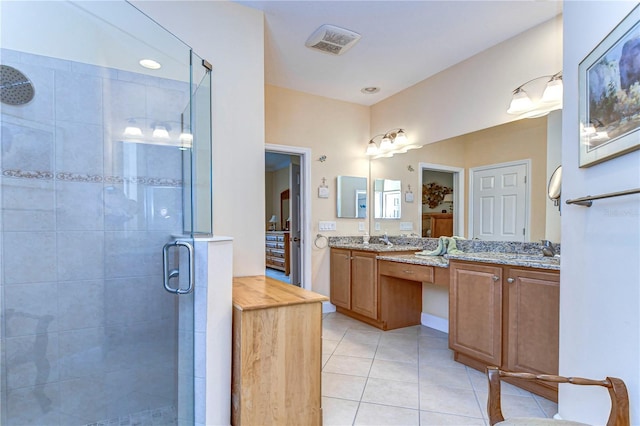 bathroom with walk in shower, vanity, and tile patterned flooring