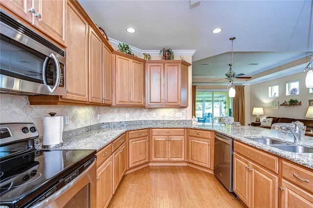 kitchen with pendant lighting, sink, light stone counters, stainless steel appliances, and crown molding