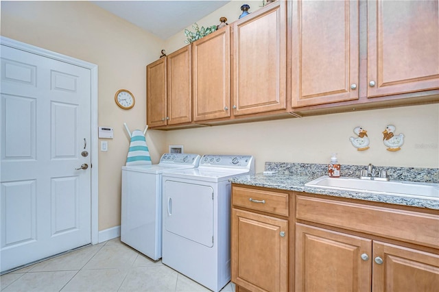 washroom featuring cabinets, sink, washing machine and dryer, and light tile patterned floors