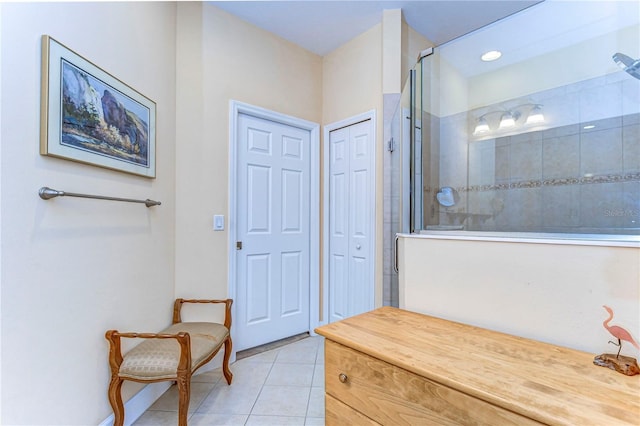 bathroom with a tile shower and tile patterned floors