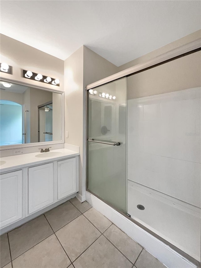 bathroom with tile patterned flooring, vanity, and an enclosed shower