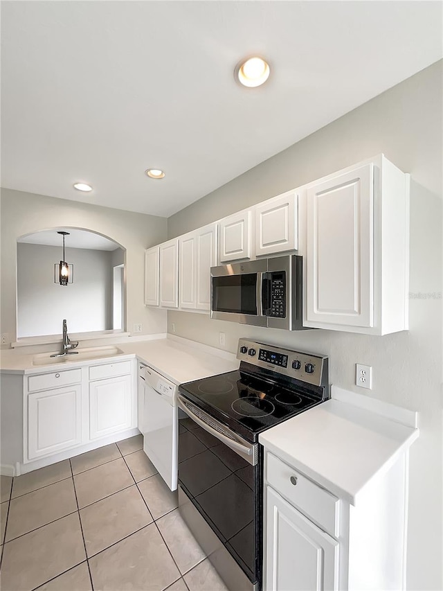 kitchen with decorative light fixtures, stainless steel appliances, and white cabinets