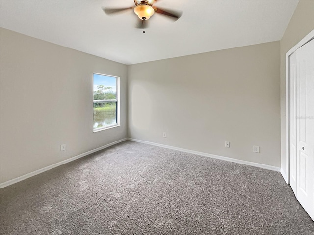 carpeted spare room with ceiling fan