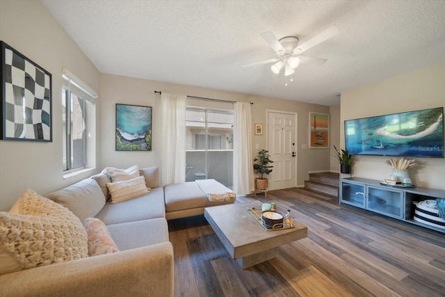 living room featuring ceiling fan, a textured ceiling, and dark hardwood / wood-style flooring