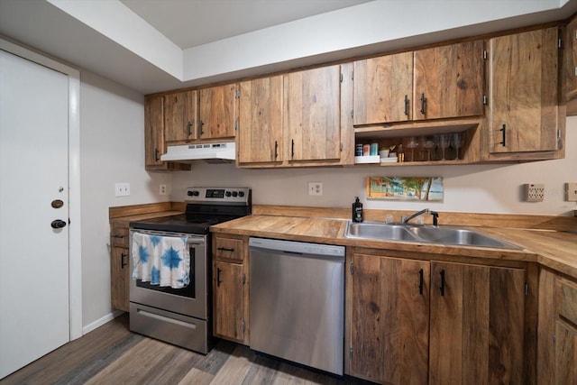 kitchen featuring stainless steel appliances, dark wood-type flooring, sink, and wood counters