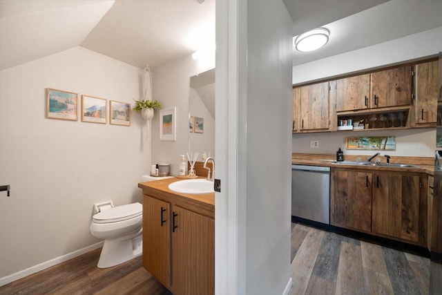 bathroom with wood-type flooring, vaulted ceiling, vanity, and toilet