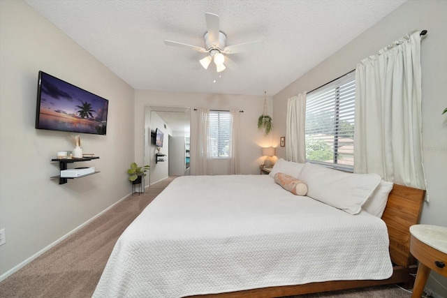 bedroom with a textured ceiling, carpet flooring, and ceiling fan