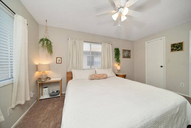 carpeted bedroom with ceiling fan and a textured ceiling