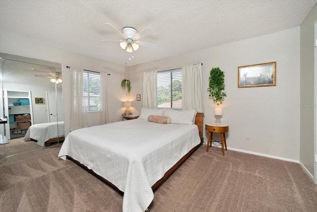 carpeted bedroom featuring ceiling fan and a textured ceiling