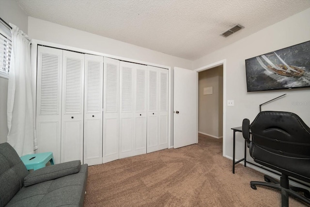 carpeted home office with a textured ceiling