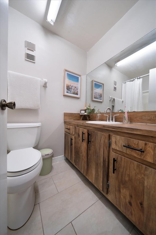 bathroom with vanity, tile patterned flooring, and toilet