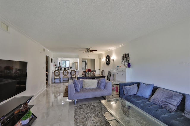 living room with ceiling fan, marble finish floor, a textured ceiling, and ornamental molding