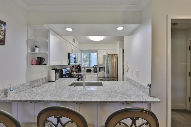 kitchen with a peninsula, crown molding, open shelves, and stainless steel appliances