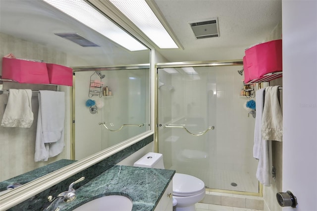 bathroom with a shower stall, toilet, vanity, and visible vents
