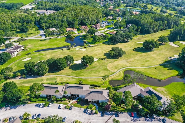 drone / aerial view with a water view and view of golf course