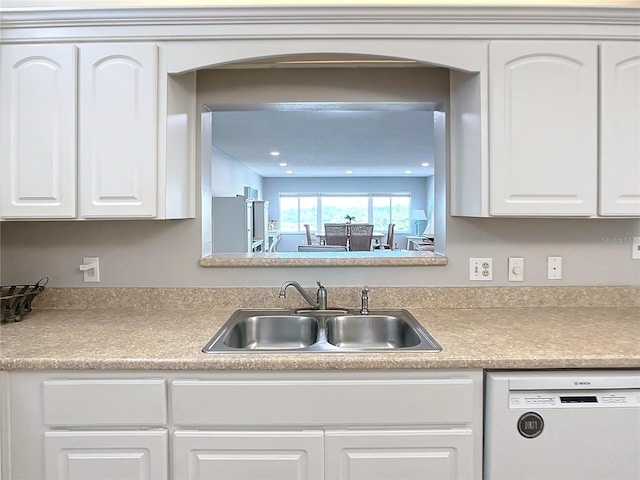 kitchen featuring white cabinets, white dishwasher, and sink