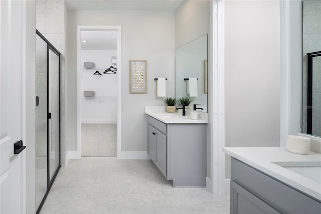 bathroom featuring vanity, a shower with shower door, and tile patterned flooring