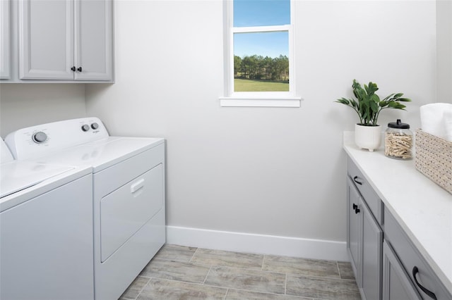 washroom featuring washer and clothes dryer and cabinets