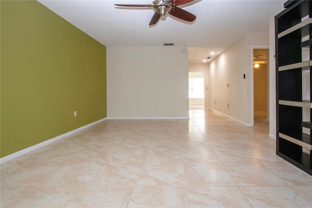 spare room with ceiling fan and light tile patterned flooring