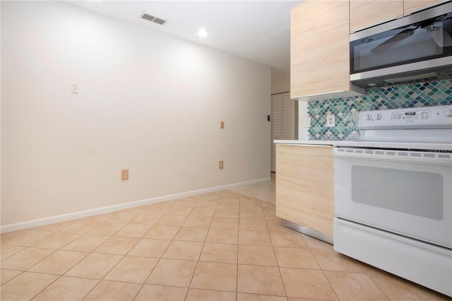 kitchen featuring electric stove, light tile patterned floors, light brown cabinets, and tasteful backsplash