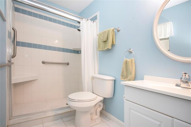 bathroom with tile patterned floors, curtained shower, vanity, and toilet