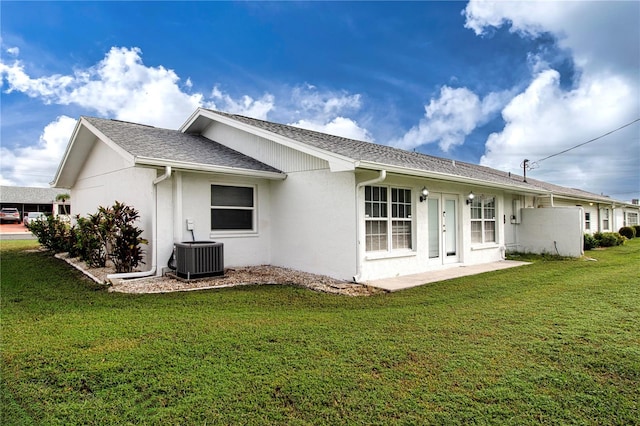 rear view of house with a yard, a patio, and central AC