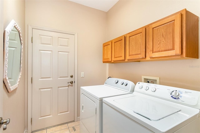 washroom featuring cabinets, independent washer and dryer, and light tile patterned flooring