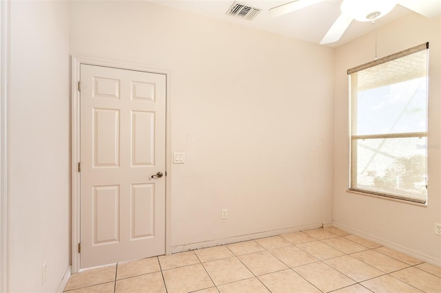 tiled empty room featuring ceiling fan