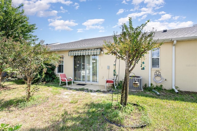 back of property featuring central AC and a yard