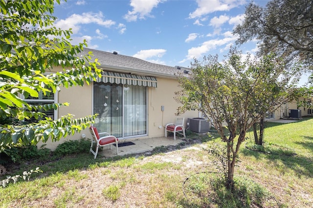 back of property with a lawn and central air condition unit