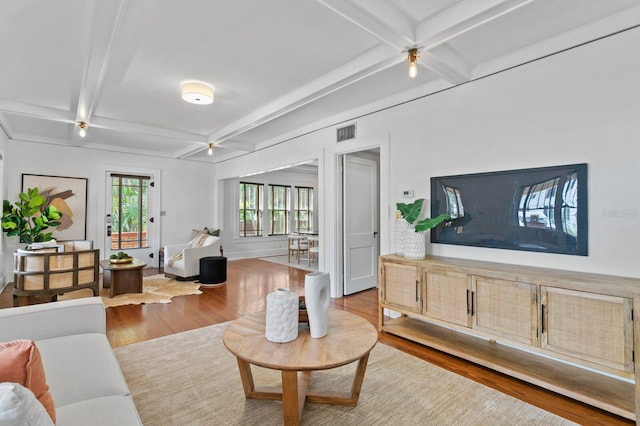 living room featuring light wood-type flooring, beam ceiling, and coffered ceiling