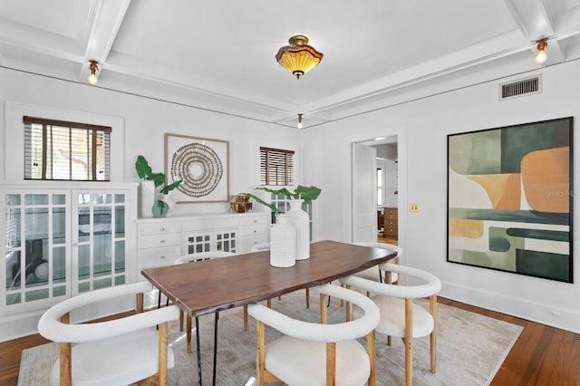 dining space with hardwood / wood-style flooring and beam ceiling