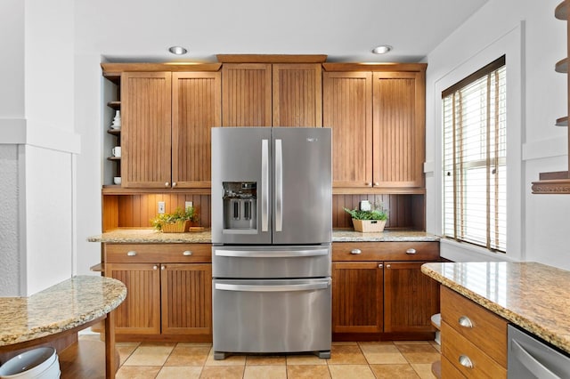 kitchen featuring light stone counters, light tile patterned flooring, and stainless steel appliances