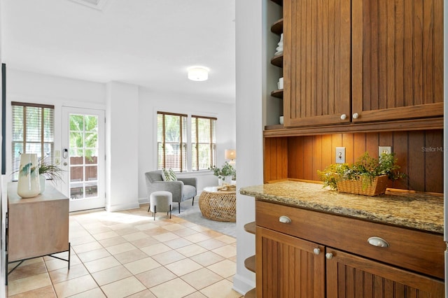 interior space with light stone counters, light tile patterned flooring, and plenty of natural light