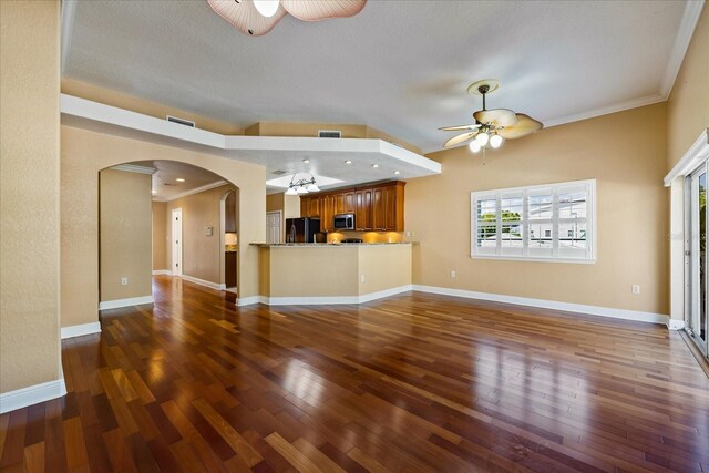 unfurnished living room featuring ornamental molding, dark wood finished floors, and a ceiling fan