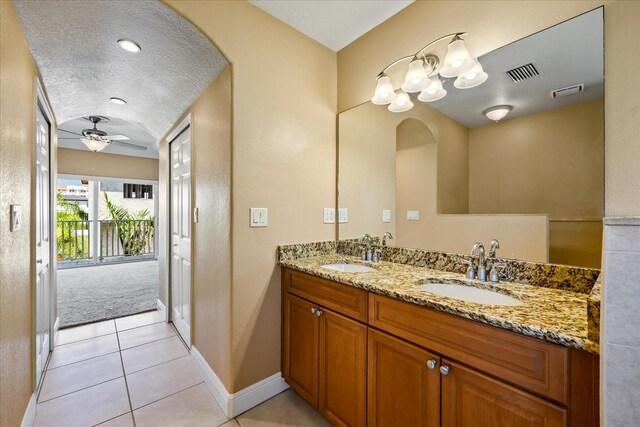 bathroom with vanity, ceiling fan, tile patterned floors, and a textured ceiling