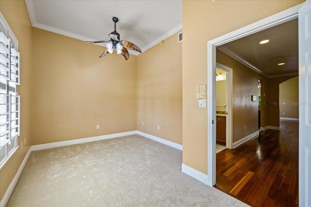 carpeted empty room with ceiling fan, arched walkways, recessed lighting, baseboards, and crown molding