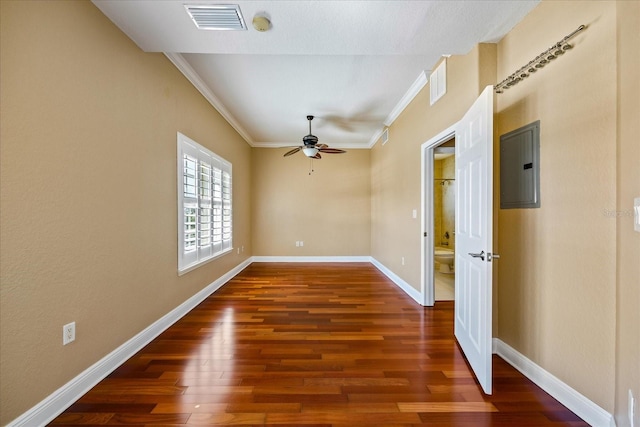 spare room with dark wood-type flooring, visible vents, baseboards, ornamental molding, and electric panel