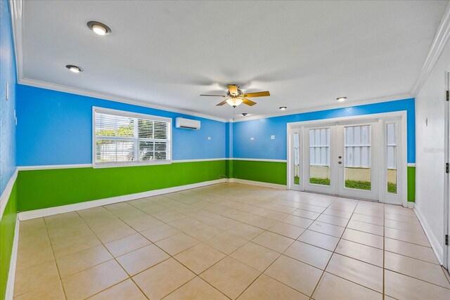 spare room featuring an AC wall unit, light tile patterned floors, crown molding, ceiling fan, and french doors