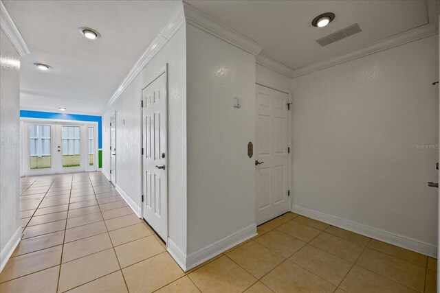 hall with french doors, light tile patterned flooring, and crown molding