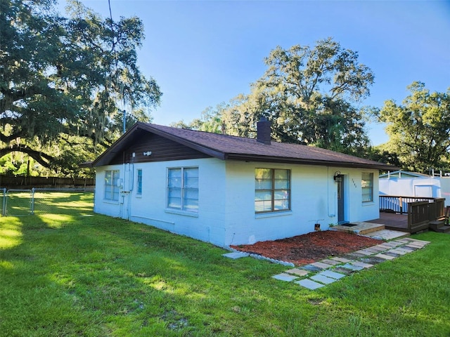 back of house featuring a deck and a yard