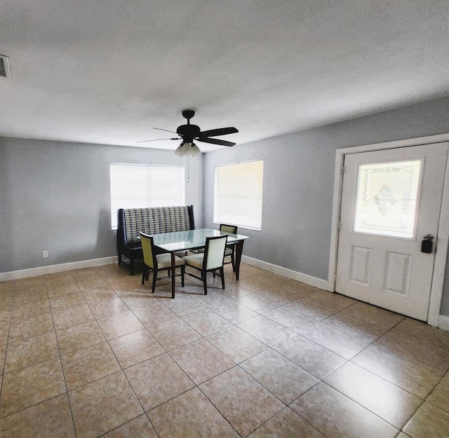 tiled dining area featuring ceiling fan and a textured ceiling