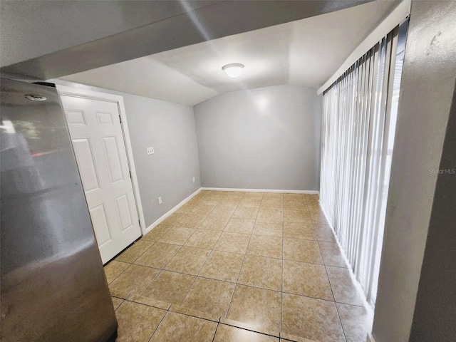 tiled empty room with lofted ceiling