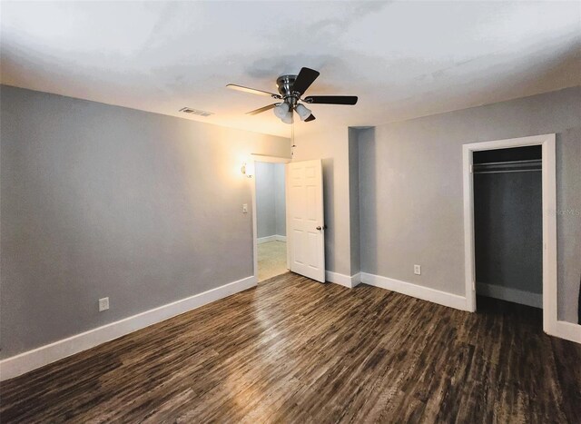 unfurnished bedroom with dark hardwood / wood-style flooring, ceiling fan, and a closet