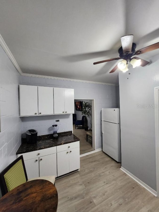 kitchen featuring white cabinetry, white fridge, light hardwood / wood-style flooring, ornamental molding, and ceiling fan