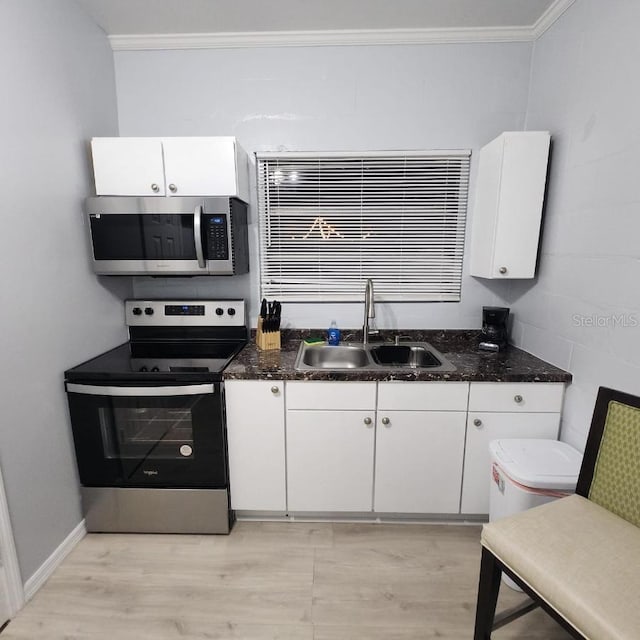 kitchen featuring ornamental molding, white cabinetry, appliances with stainless steel finishes, and sink