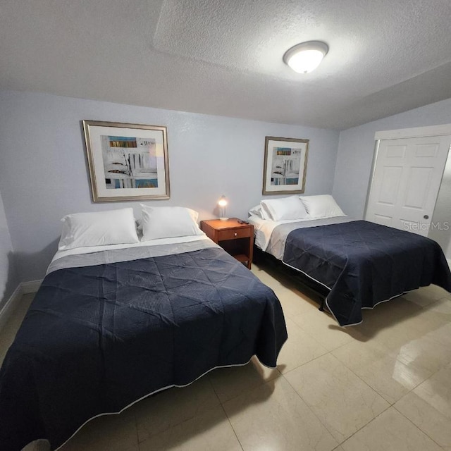 bedroom featuring a textured ceiling and vaulted ceiling