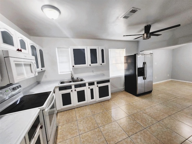 kitchen with stainless steel fridge, white cabinetry, ceiling fan, sink, and electric range