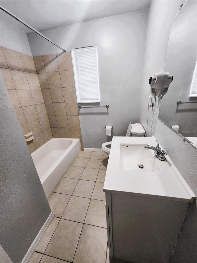 full bathroom with tile patterned flooring, vanity, toilet, and tiled shower / bath