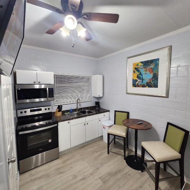 kitchen with white cabinetry, ceiling fan, appliances with stainless steel finishes, and light hardwood / wood-style floors